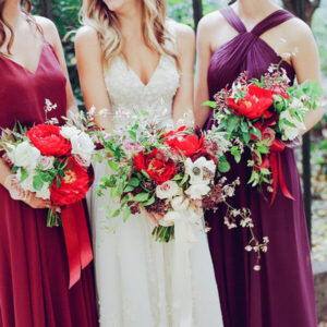 bride and bridesmaids with red peony bouquets
