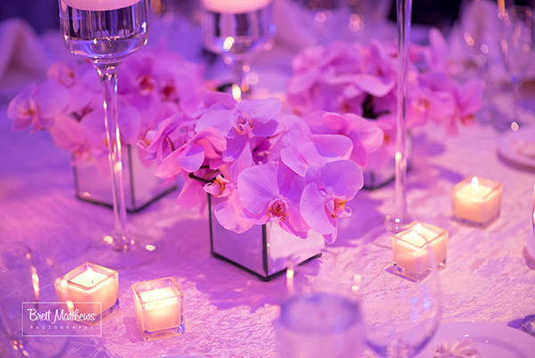 Orchid centerpieces in mirror vases.