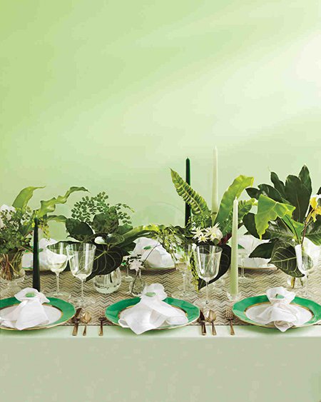 a green tablescape from Martha Stewart Weddings with foliage centerpieces accented with flowers on a long table
