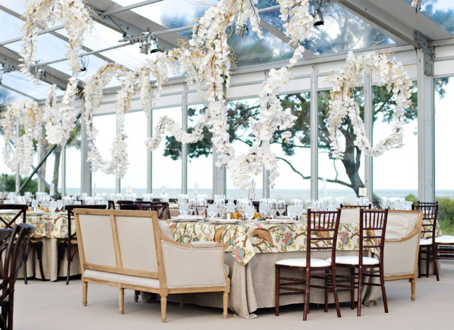 White Phalaenopsis orchids cascade over wedding reception tables