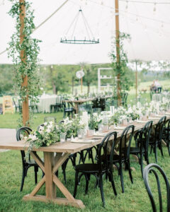 white wedding tent long tables with leafy garlands