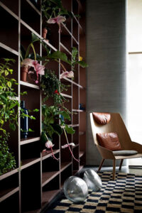 tall bookcase in modern apartment filled with potted plants