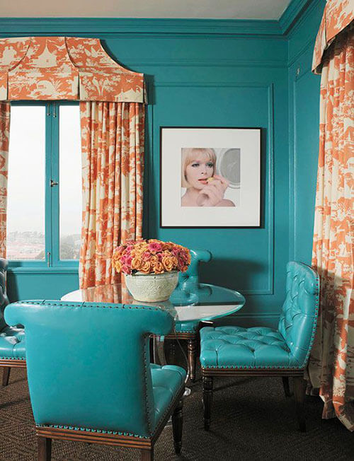 teal dining room with orange flower curtains