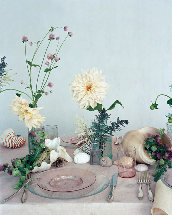 beach wedding centerpiece with dahlias in bud vases seashells and conch