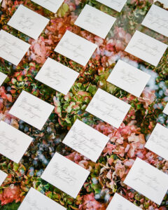 calligraphed wedding escort cards over a bed of hydrangeas