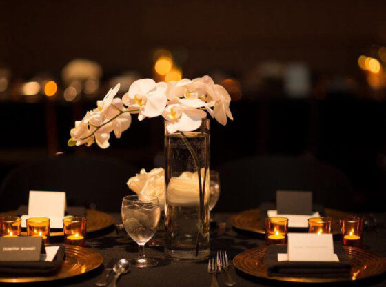 wedding reception tablescape with white orchids on black tablecloths style me pretty