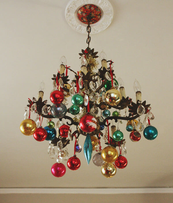 chandelier with vintage christmas ornament balls hanging from it as classic christmas decor 